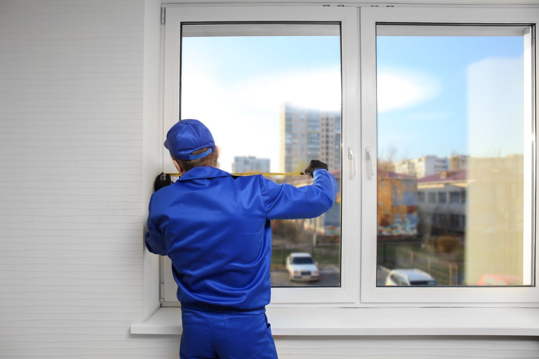 Construction Worker Repairing Window in House